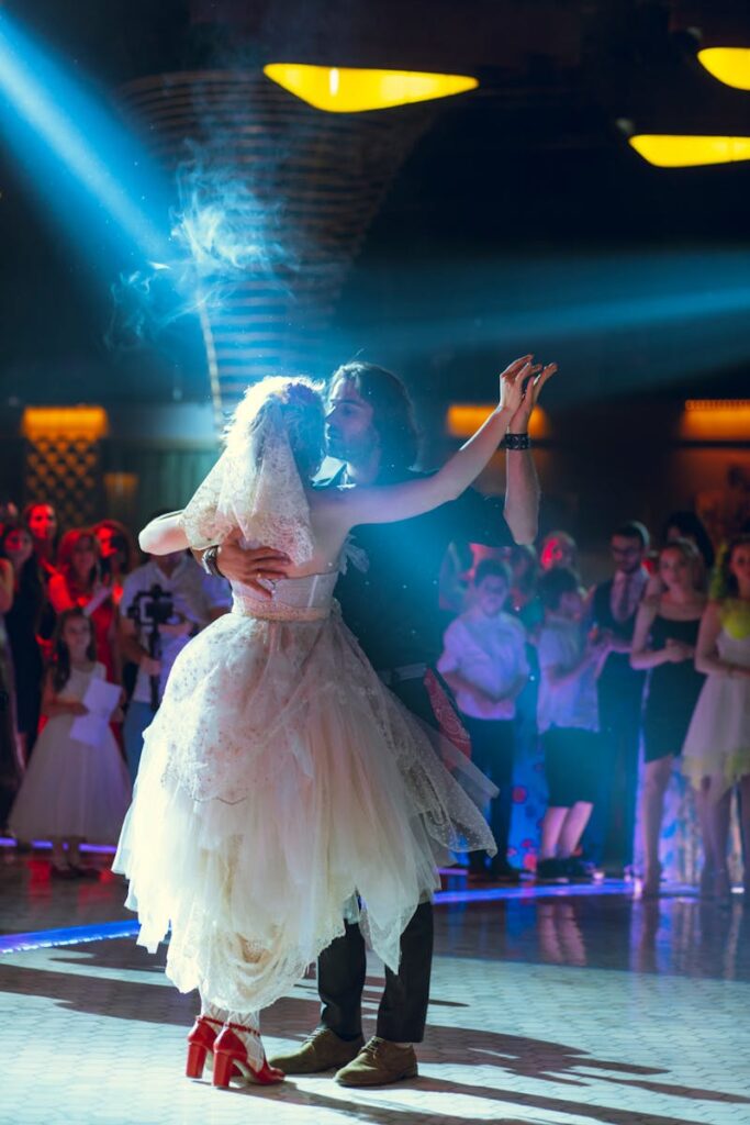 Newlyweds share their first dance on the dance floor, surrounded by friends and family under soft disco lights, creating a warm and joyful atmosphere.