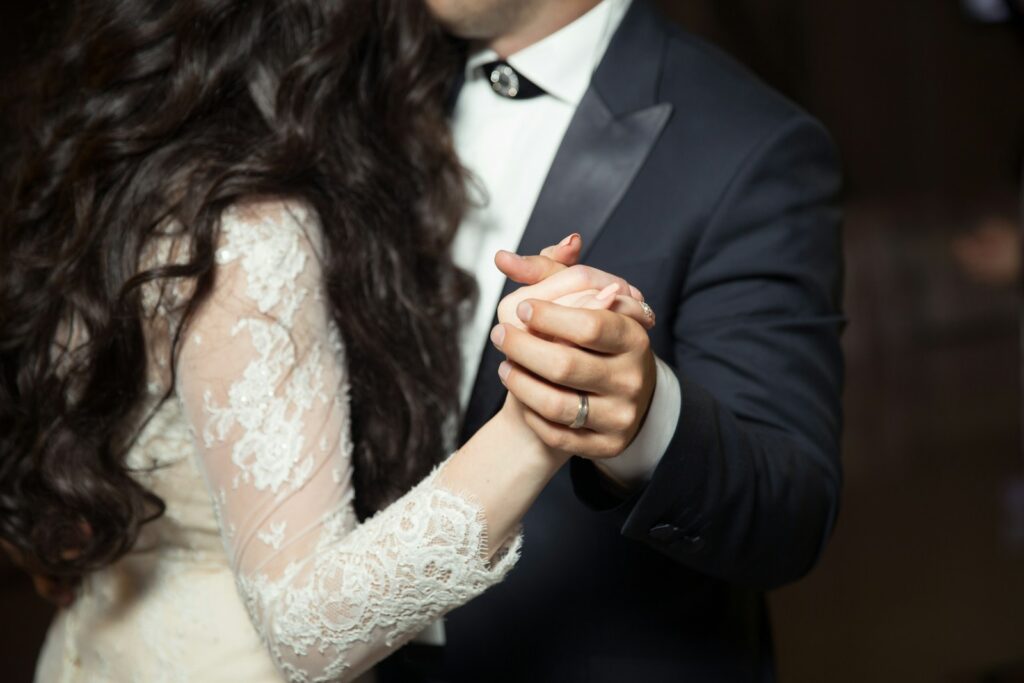 Newlywed couple shares their first wedding dance, holding each other closely, symbolizing unity and love as they step into their new life together.