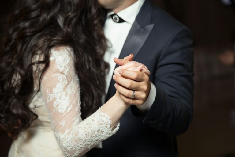 Newlywed couple shares their first wedding dance, holding each other closely, symbolizing unity and love as they step into their new life together.