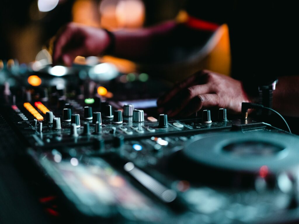Close-up of hands on a DJ turntable, mixing music at a wedding reception, setting the perfect mood for the couple's first dance and celebration.